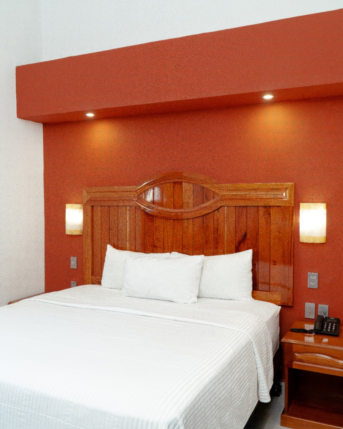Habitación del Hotel Casa Danna con cabecera de madera tallada