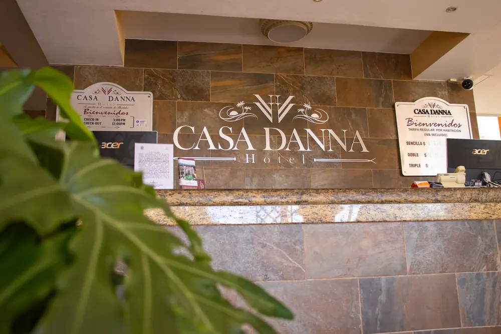 Letrero de recepción de Casa Danna Huatulco con horarios y categorías